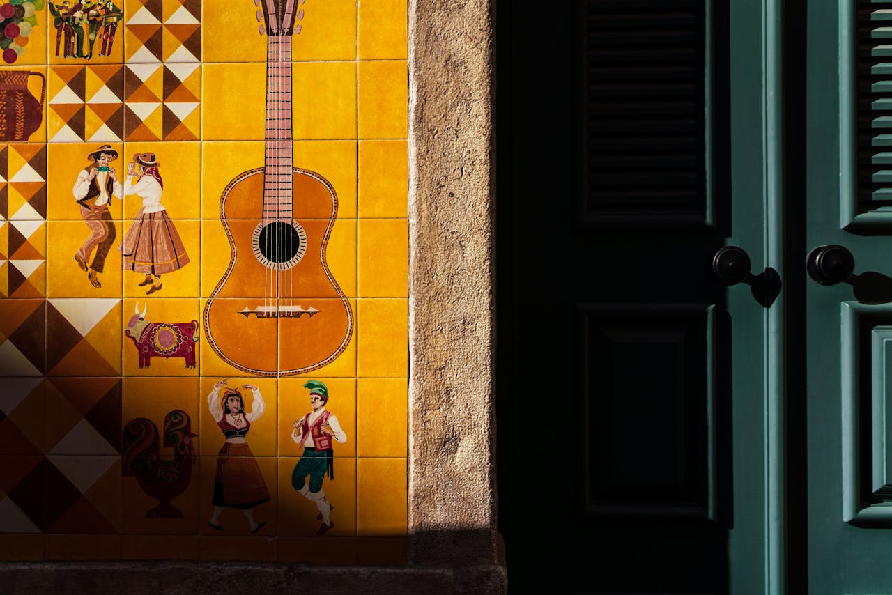 Vibrant Spanish tiles featuring a guitar and traditional dancers on a sunny wall.