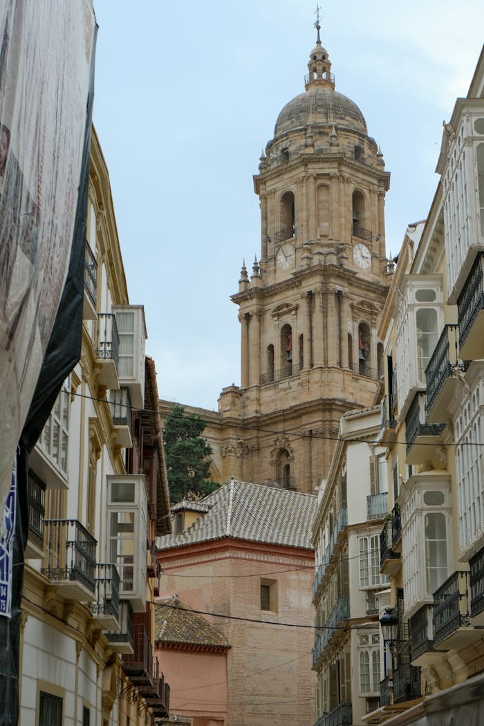 View of Málaga Cathedral tower surrounded by historic architecture in Andalusia, Spain.